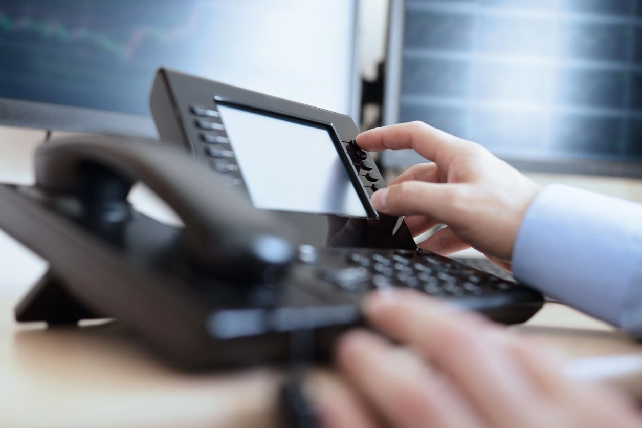 A person is using a phone on the desk