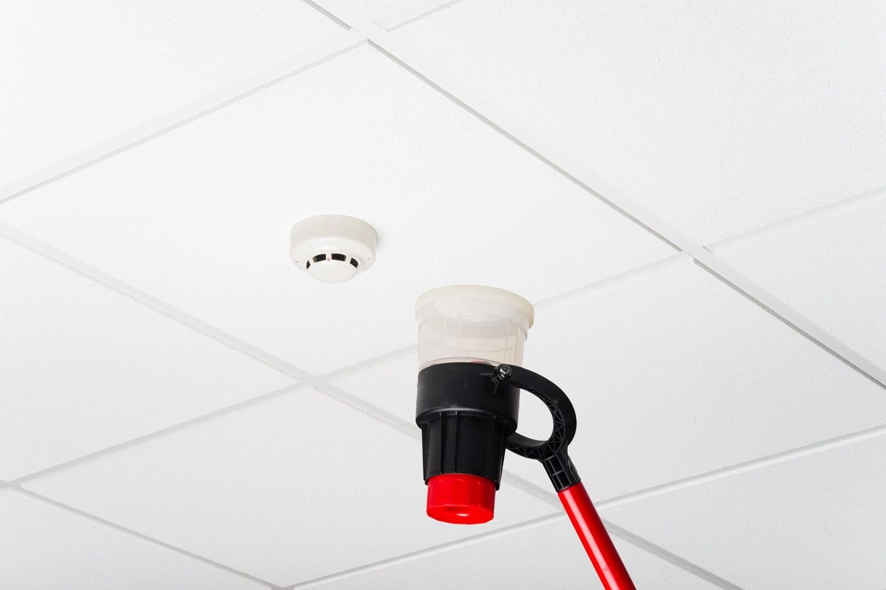 A fire hydrant is attached to the ceiling of an office.